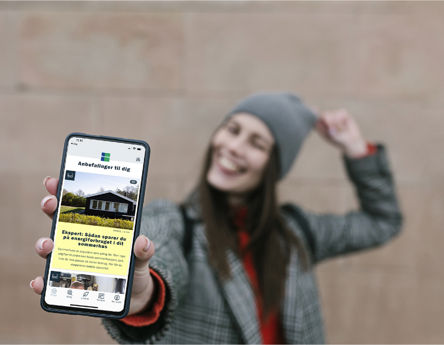 Kvinde viser mobil med boligsøger app