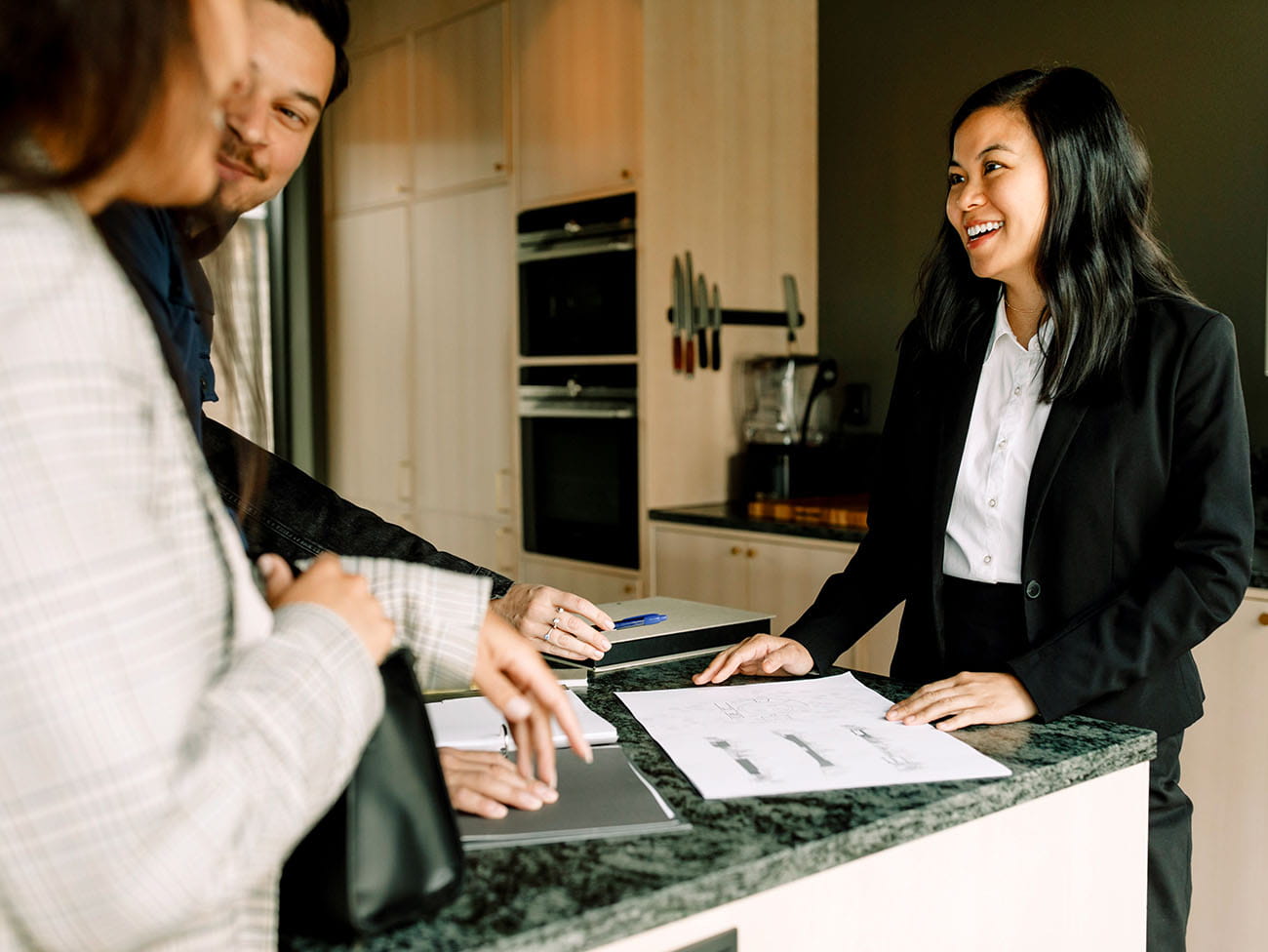 Ejendomsmægler rådgiver køberpar om boligkøb i køkken