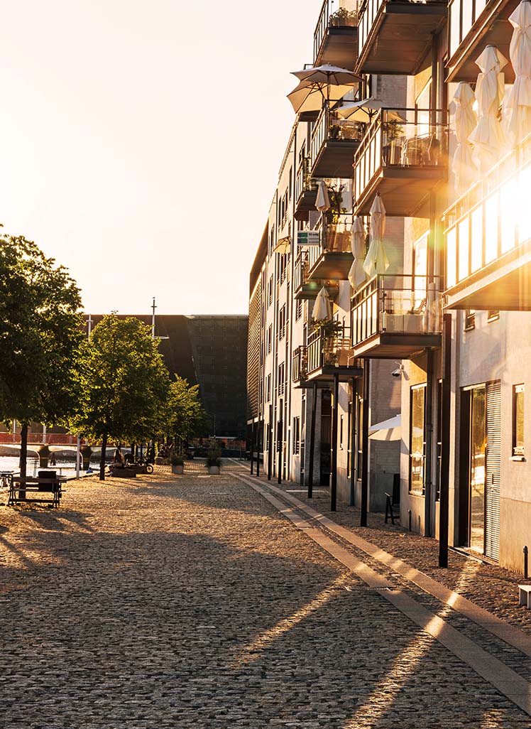 Lejligheder ved vand i attraktivt bymiljø ved solnedgang