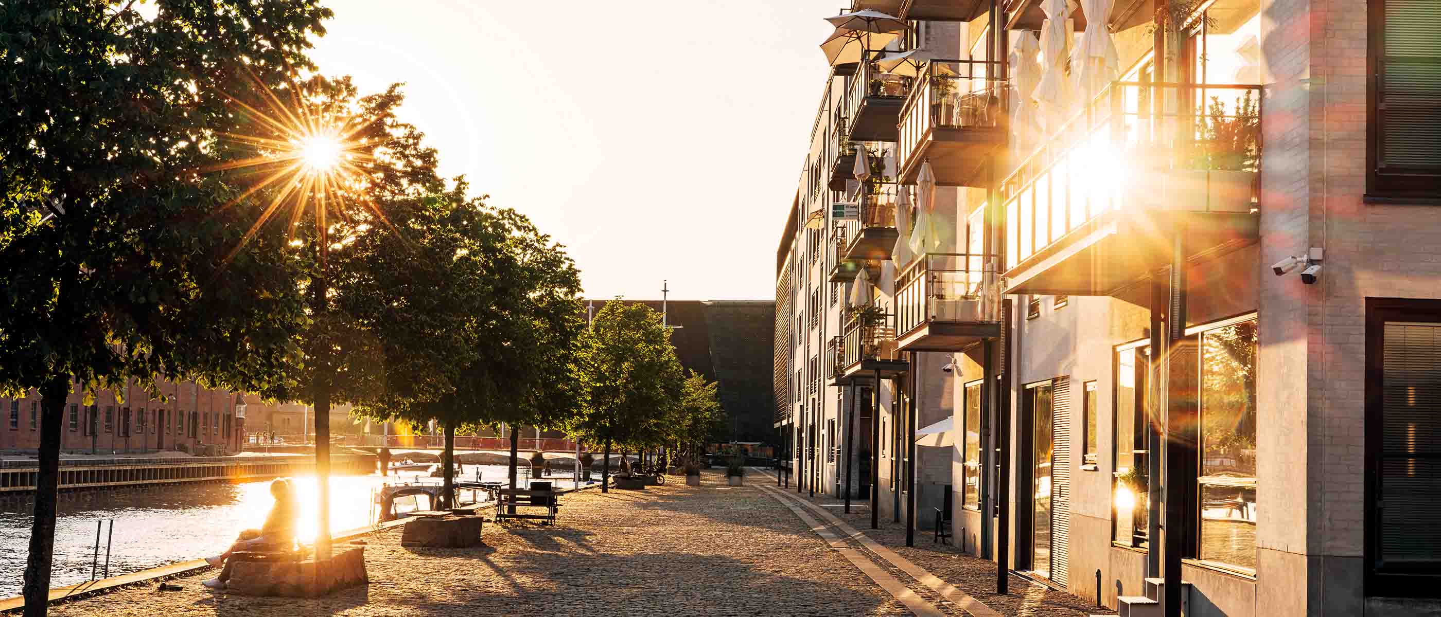 Lejligheder ved vand i attraktivt bymiljø ved solnedgang