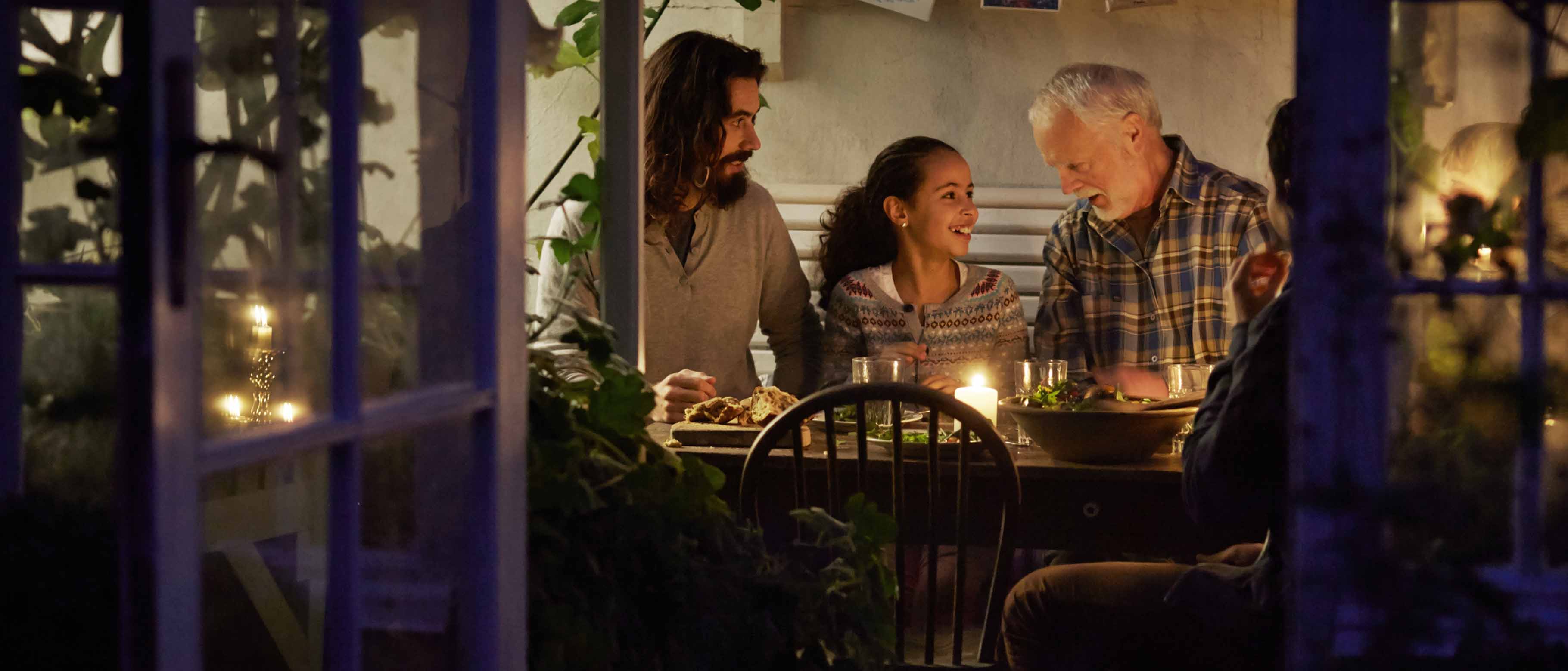 Middag med flere generationer i udestue med stearinlys