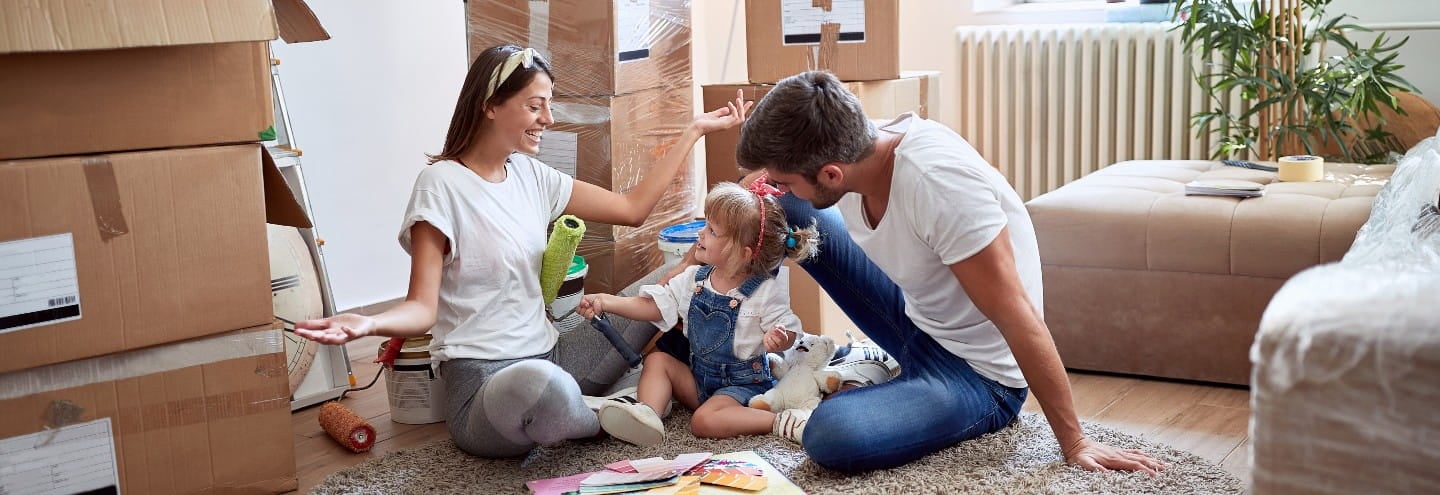 Glad familie mellem flyttekasser