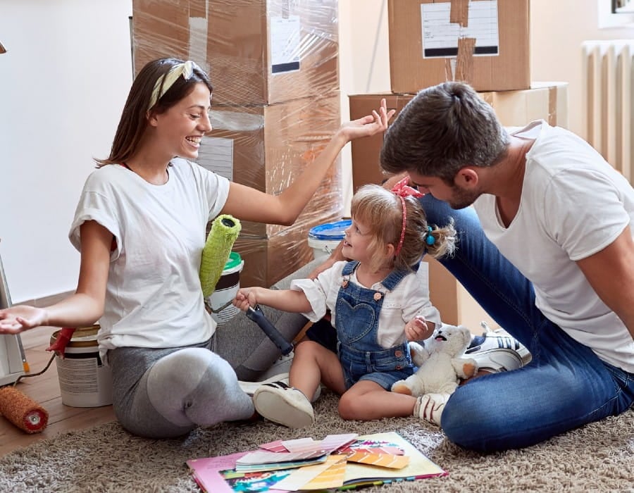 Glad familie mellem flyttekasser