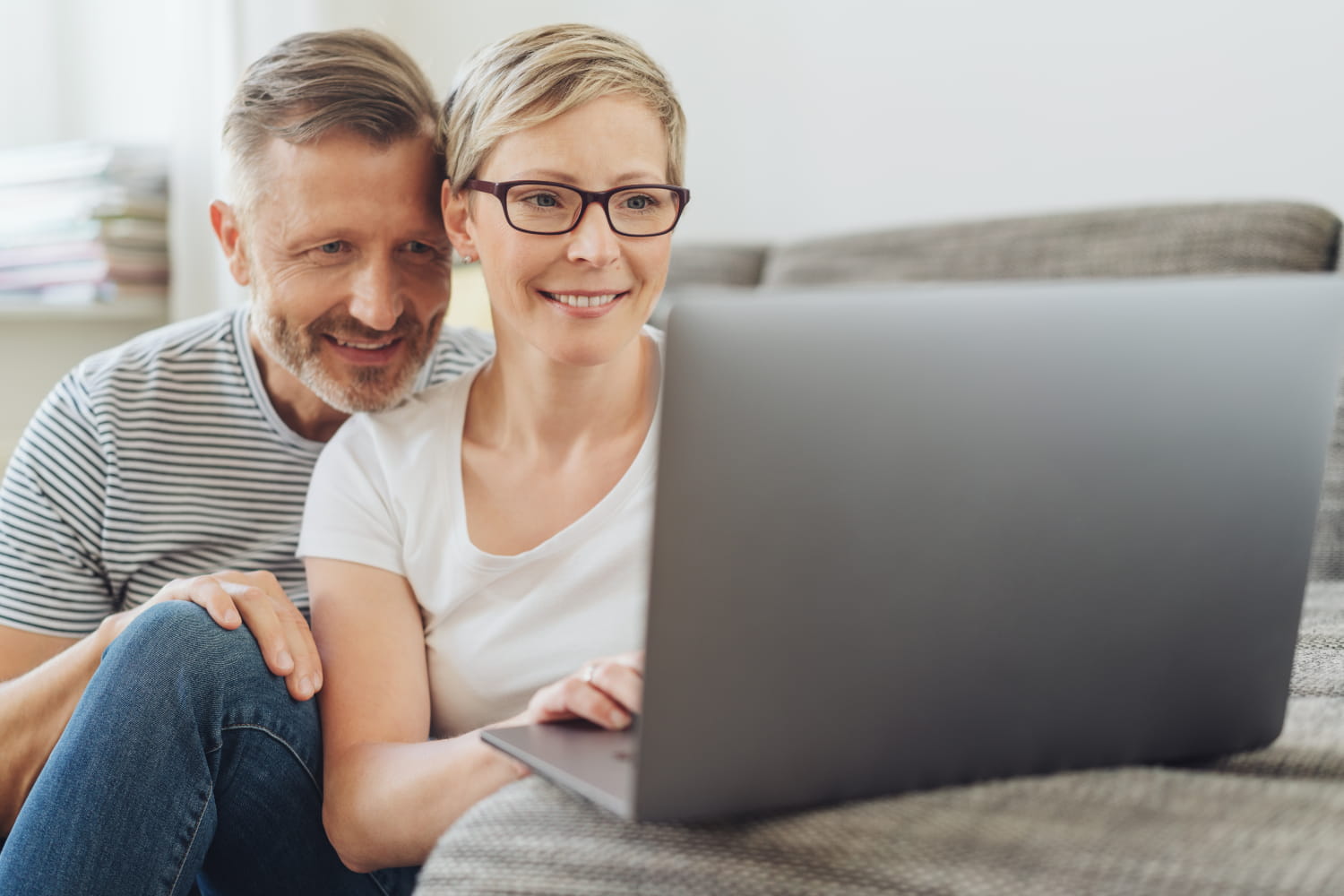 Mand og kvinde ser smilende på computer skærm