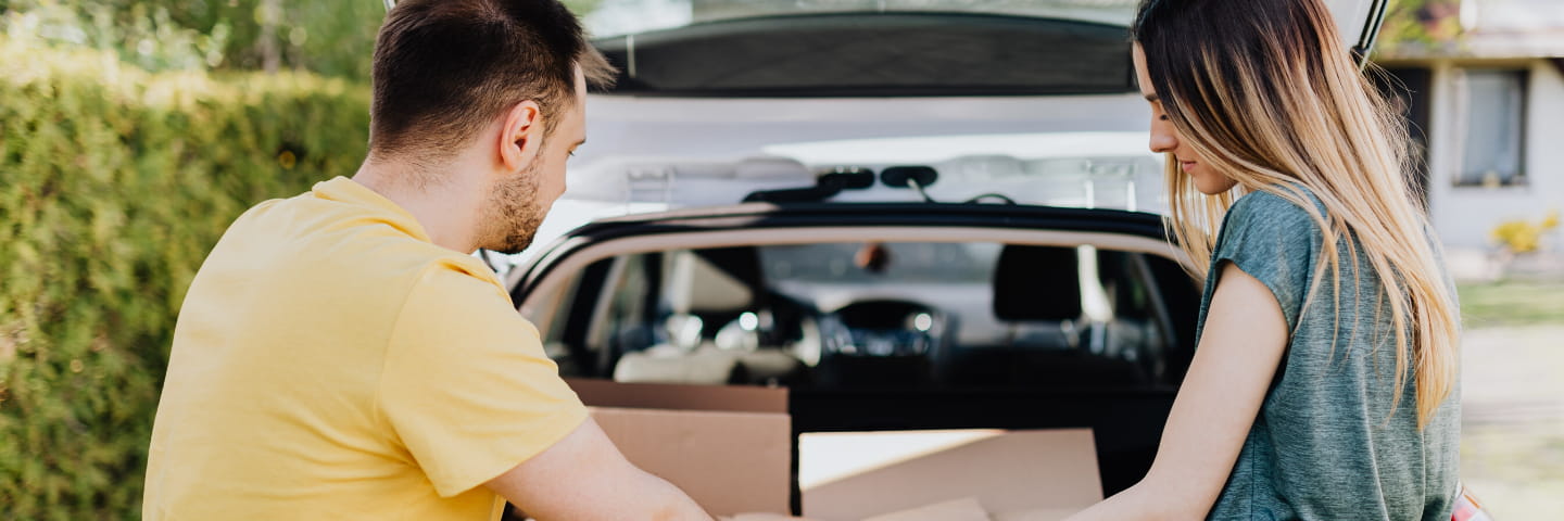 ung mand og kvinde pakker bil